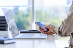 a person sitting at a table using a laptop computer